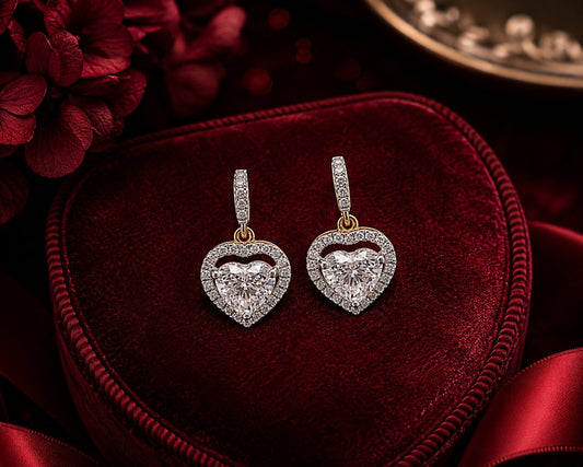 Heart halo diamond drop earrings in white and yellow gold on luxury velvet jewellery display.