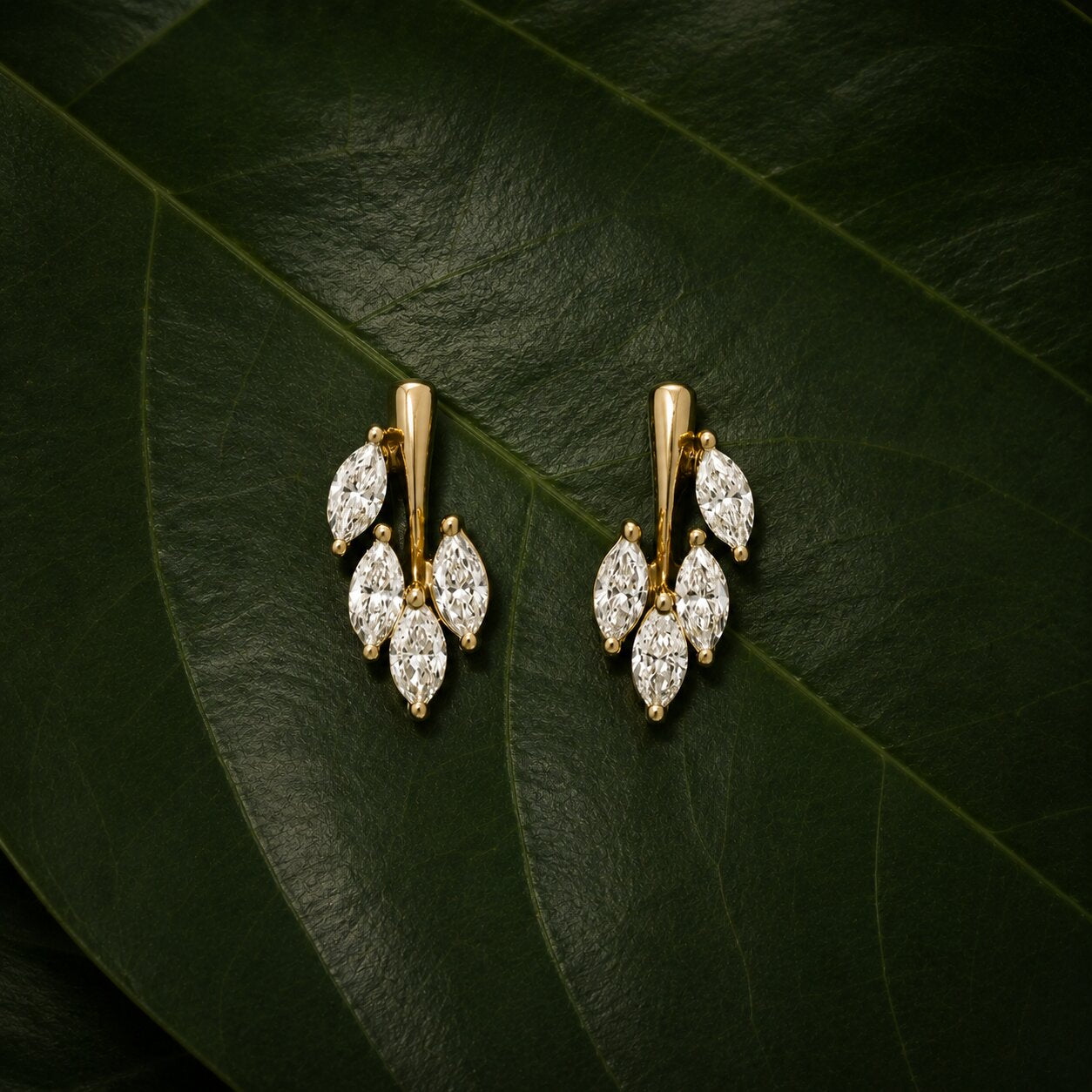 Nature-inspired diamond bracelet in gold with leaf motif on dark green tropical leaves