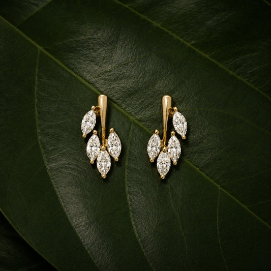 Nature-inspired diamond bracelet in gold with leaf motif on dark green tropical leaves