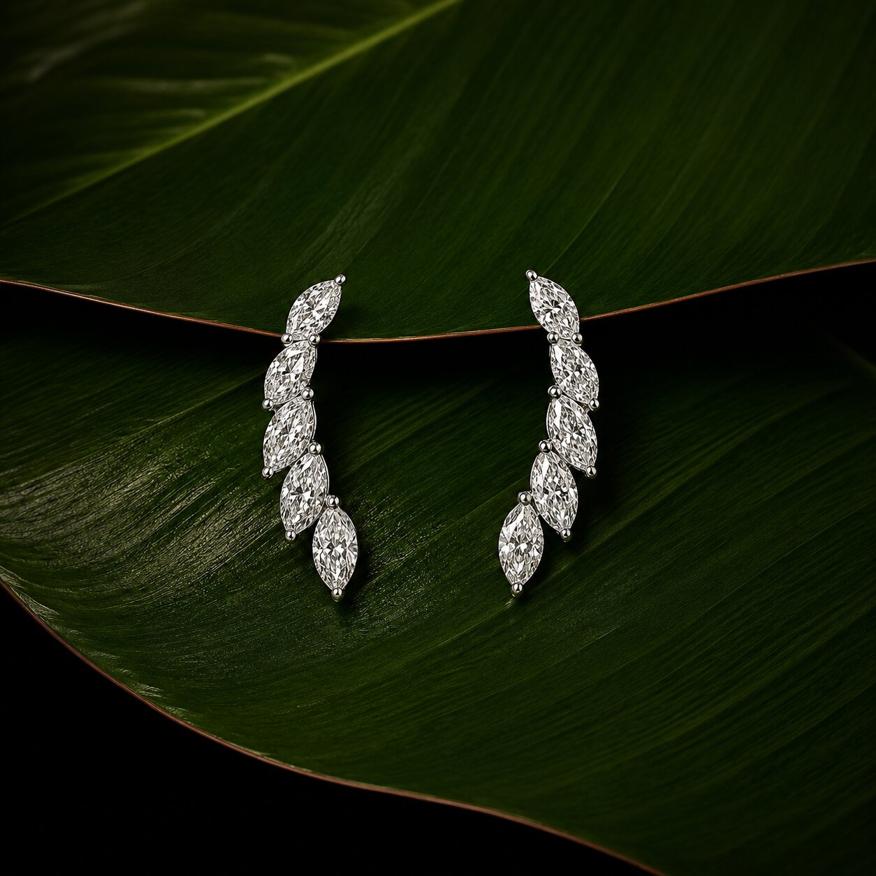 Marquise diamond drop earrings with botanical leaf-inspired design on tropical green leaf backdrop