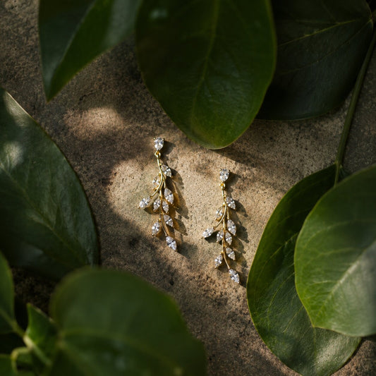 Luxury vine-inspired diamond drop earrings with botanical styling and soft natural light