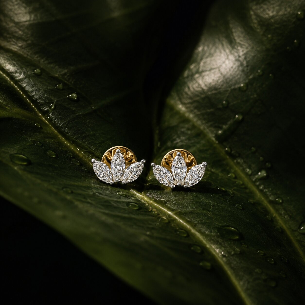 Lotus-inspired diamond stud earrings with marquise diamonds on glossy green leaf background