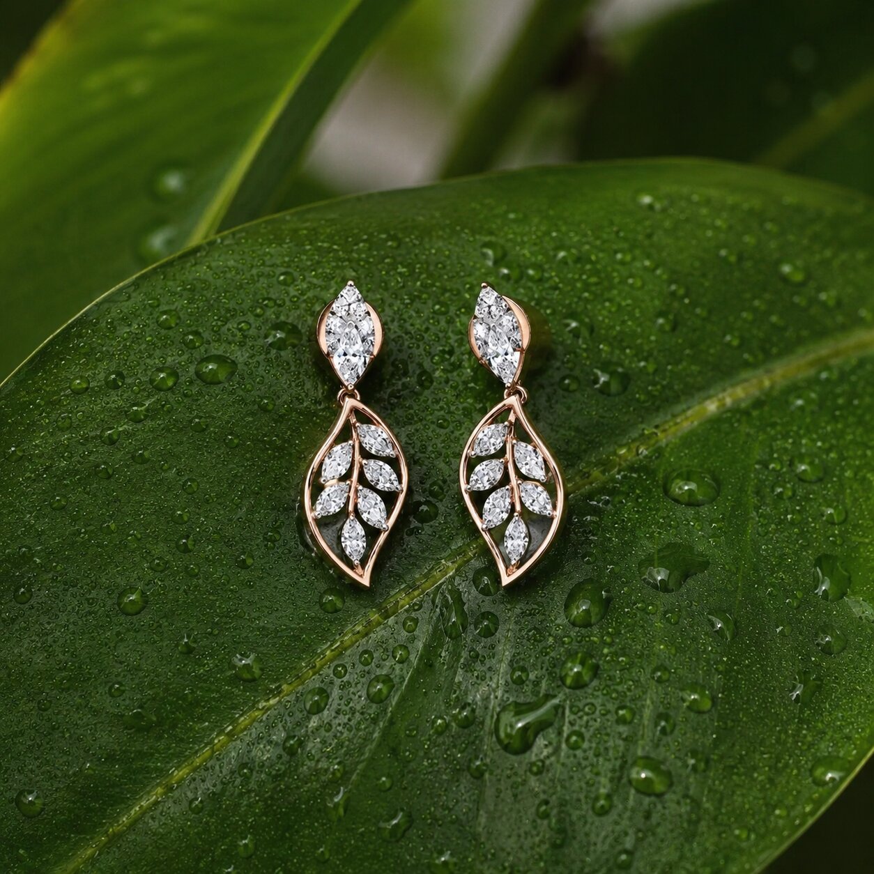 Leaf motif diamond drop earrings in rose gold with marquise-cut lab-grown diamonds on fresh green leaf