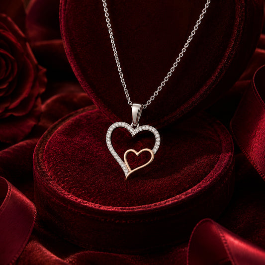 Double heart diamond pendant necklace in white and rose gold on velvet jewellery box.