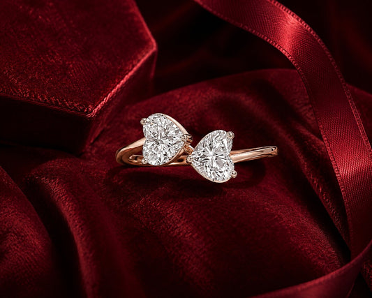 Twin heart solitaire diamond ring in rose gold on red velvet backdrop.
