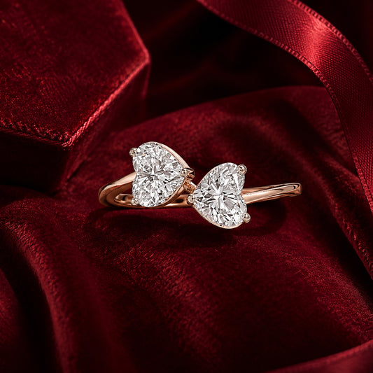 Twin heart solitaire diamond ring in rose gold on red velvet backdrop.