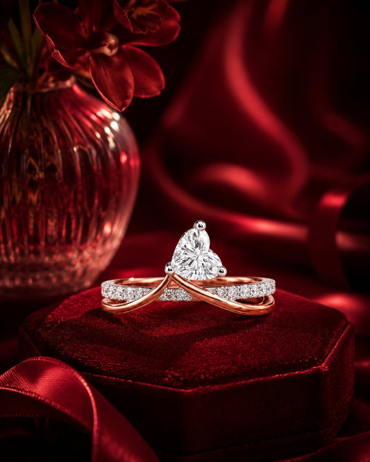 Pear-shaped diamond crossover ring in rose gold on burgundy velvet.