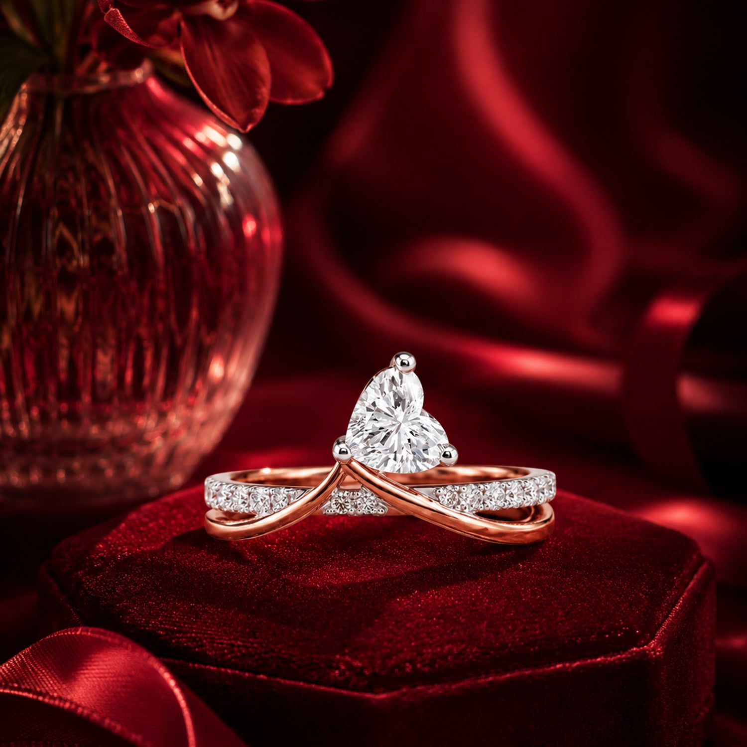 Pear-shaped diamond crossover ring in rose gold on burgundy velvet.